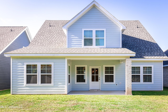 rear view of property featuring a patio and a lawn