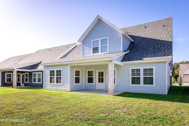 rear view of house with a patio and a yard