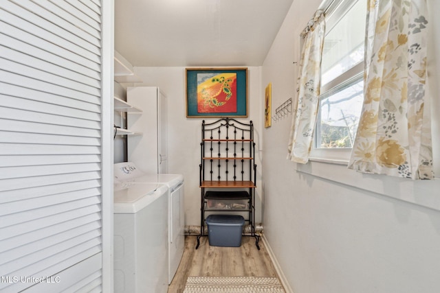 laundry room featuring washer and dryer and light hardwood / wood-style floors