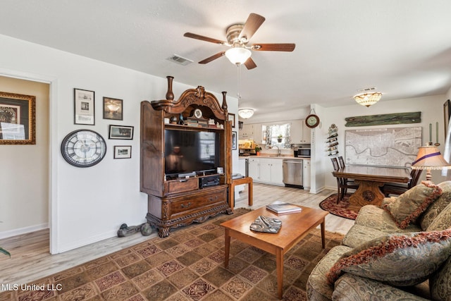 living room with ceiling fan and light hardwood / wood-style floors