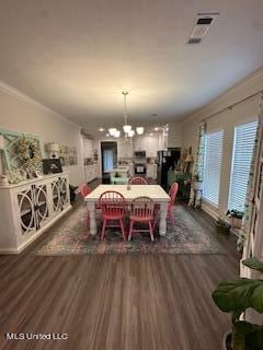 dining area featuring an inviting chandelier, ornamental molding, and dark hardwood / wood-style flooring