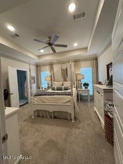 bedroom featuring ornamental molding, carpet floors, a tray ceiling, and ceiling fan