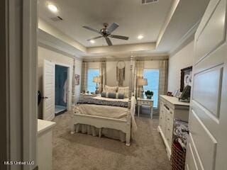 bedroom featuring a raised ceiling, carpet flooring, and multiple windows