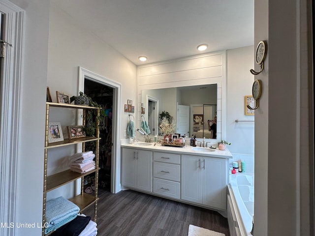 bathroom featuring vanity, hardwood / wood-style floors, and a bathtub