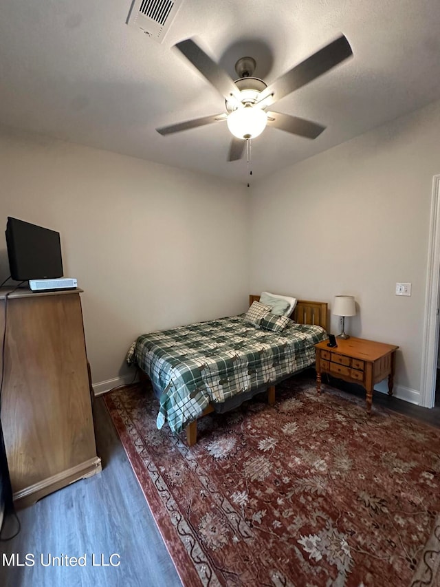 bedroom with dark hardwood / wood-style floors and ceiling fan