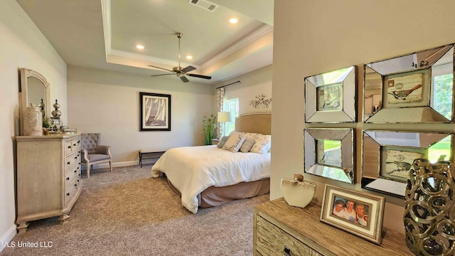 carpeted bedroom with ceiling fan, a raised ceiling, crown molding, and multiple windows