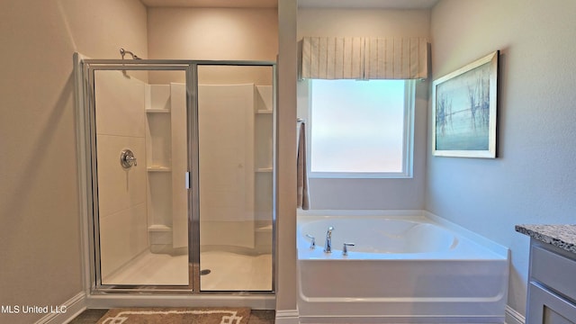 bathroom featuring vanity and independent shower and bath