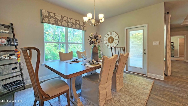 dining space featuring wood-type flooring and a chandelier