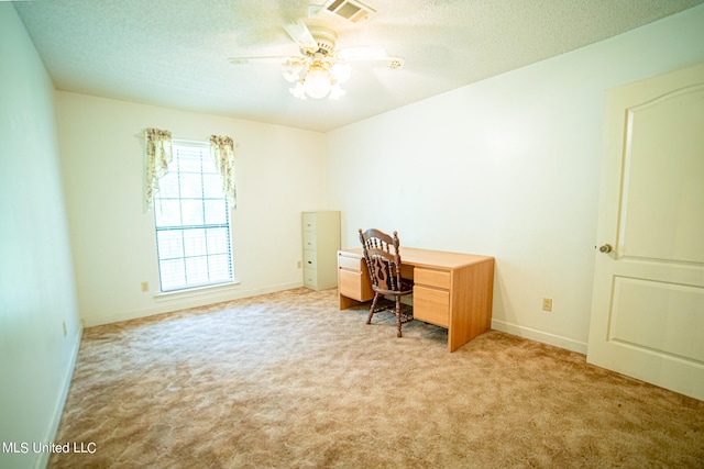 carpeted home office with a textured ceiling and ceiling fan