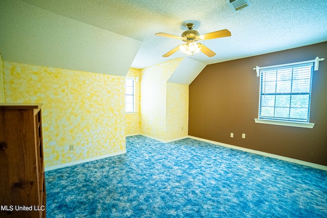 bonus room with a textured ceiling, ceiling fan, carpet flooring, and vaulted ceiling