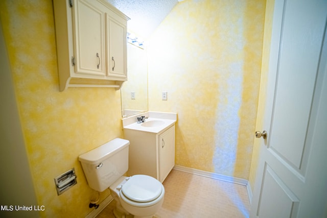 bathroom with vanity, a textured ceiling, and toilet