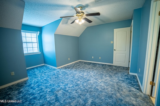 additional living space featuring ceiling fan, a textured ceiling, vaulted ceiling, and dark colored carpet