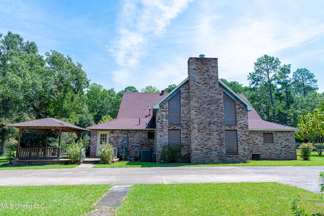 view of front of house with central air condition unit and a front yard