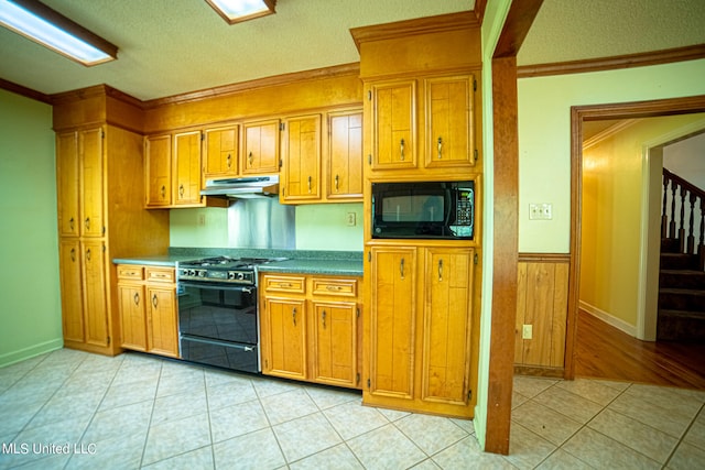 kitchen with light tile patterned flooring, crown molding, a textured ceiling, and black appliances