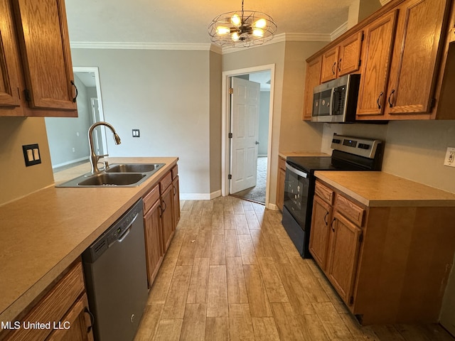 kitchen with sink, hanging light fixtures, crown molding, a notable chandelier, and stainless steel appliances