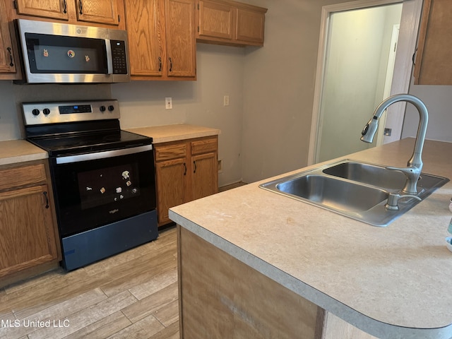 kitchen featuring sink, light hardwood / wood-style flooring, and black range with electric cooktop