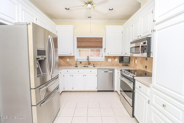 kitchen featuring ceiling fan, decorative backsplash, a sink, light countertops, and stainless steel appliances