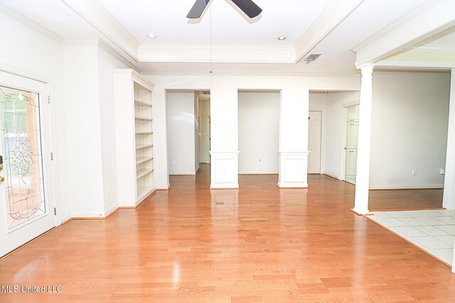 unfurnished living room featuring a ceiling fan, crown molding, baseboards, ornate columns, and light wood-style flooring