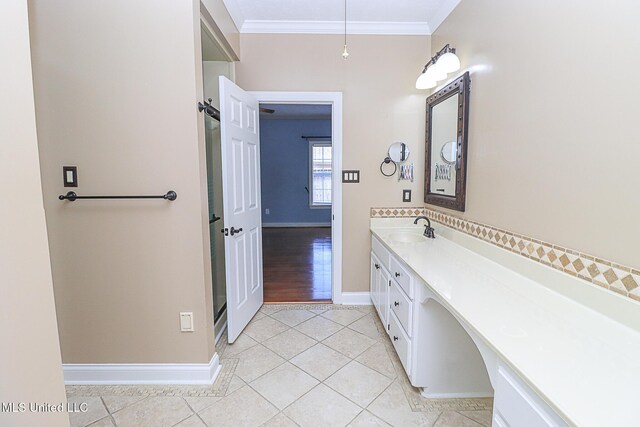 bathroom with tile patterned floors, ornamental molding, baseboards, and vanity