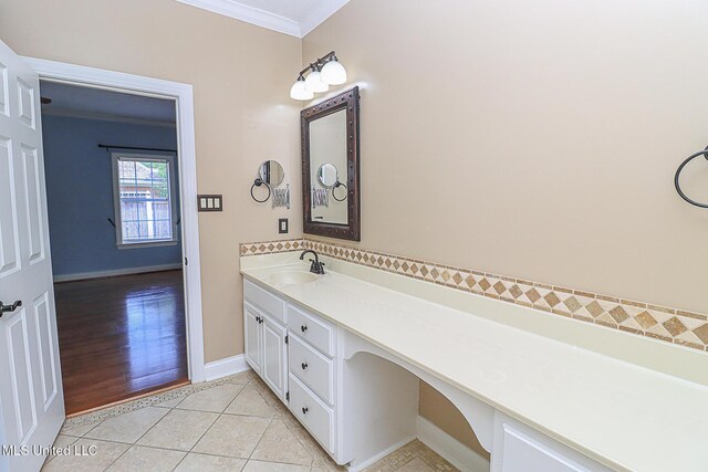 bathroom featuring crown molding, baseboards, tile patterned flooring, and vanity