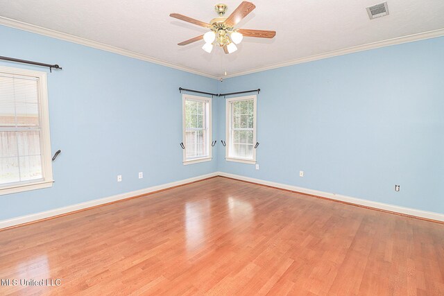 unfurnished room with visible vents, baseboards, ceiling fan, and wood finished floors