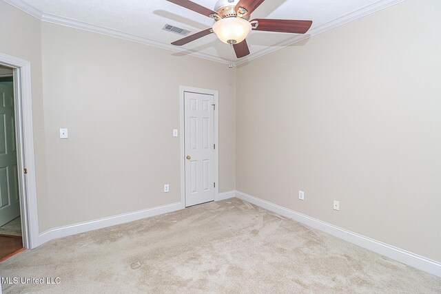 spare room with ceiling fan, light carpet, baseboards, visible vents, and ornamental molding
