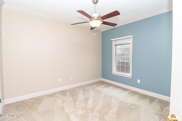 carpeted empty room featuring a ceiling fan, baseboards, and ornamental molding