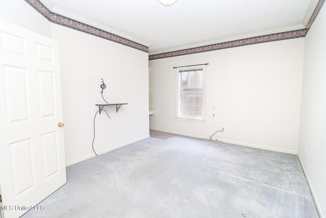 unfurnished room with carpet floors, ornamental molding, and baseboards