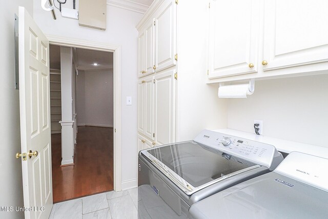 washroom featuring independent washer and dryer, baseboards, and cabinet space
