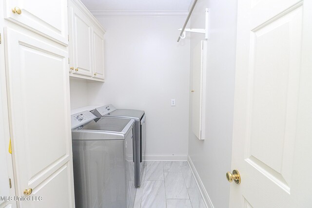 washroom with cabinet space, separate washer and dryer, marble finish floor, baseboards, and ornamental molding