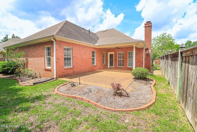 rear view of property with brick siding, a patio area, fence, and a chimney