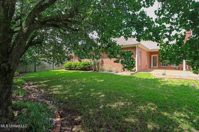 view of yard featuring fence and a patio