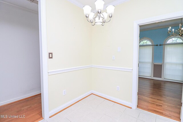 unfurnished dining area with baseboards, ornamental molding, and a chandelier