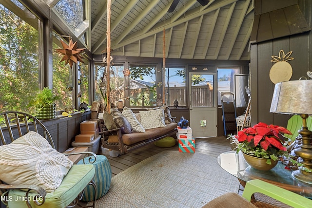 sunroom featuring lofted ceiling with beams, a healthy amount of sunlight, and wooden ceiling