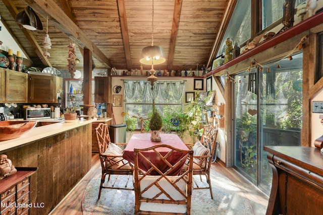 dining space with vaulted ceiling with beams, light hardwood / wood-style flooring, and wooden ceiling