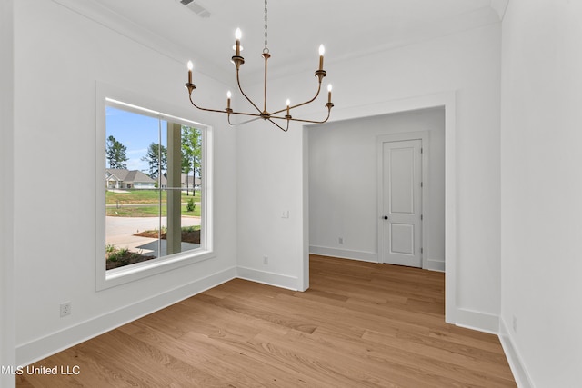 unfurnished dining area featuring a chandelier and light hardwood / wood-style floors