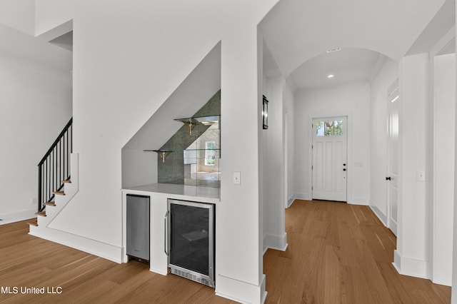 foyer with wine cooler and wood-type flooring