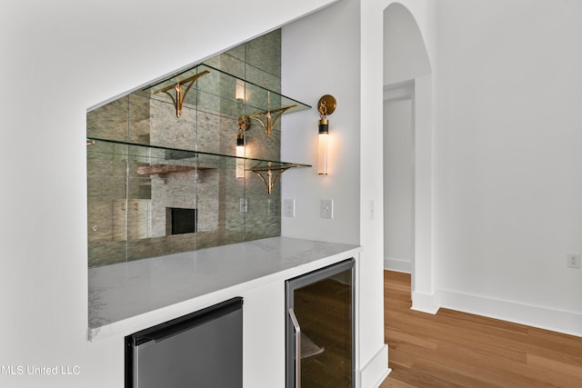 bar featuring hardwood / wood-style floors and beverage cooler