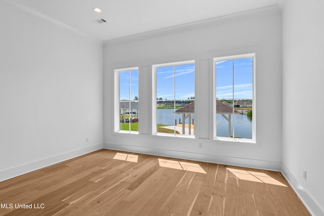 empty room with a water view and light hardwood / wood-style flooring