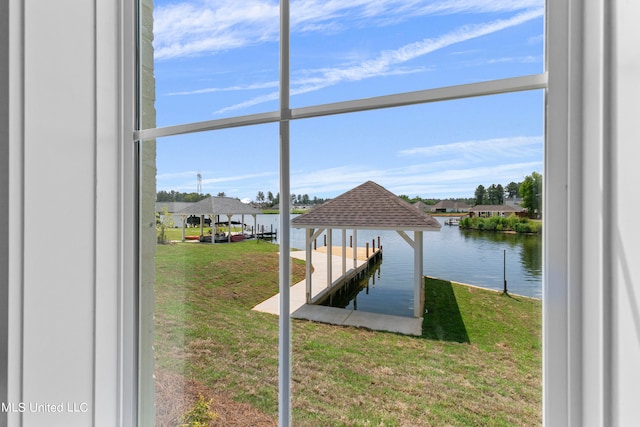 view of dock with a yard and a water view