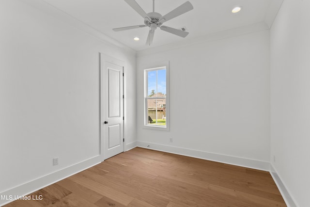 spare room with ornamental molding, light wood-type flooring, and ceiling fan