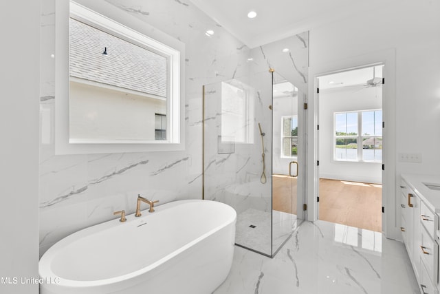 bathroom featuring tile walls, vanity, shower with separate bathtub, and ceiling fan