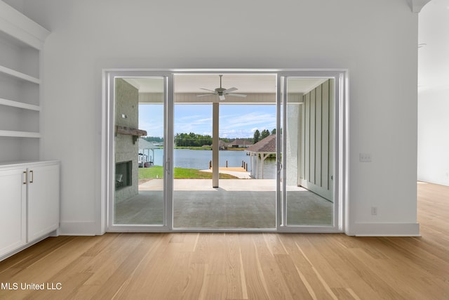 doorway featuring light hardwood / wood-style flooring, a water view, and ceiling fan