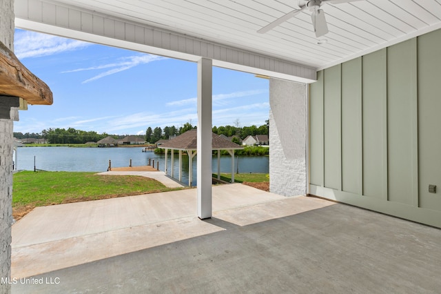 view of patio with a water view, ceiling fan, and a boat dock