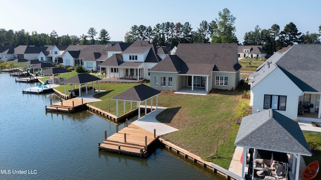 exterior space featuring a patio, a lawn, and a water view