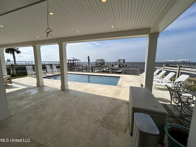 view of swimming pool with a dock and a patio area