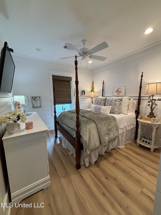 bedroom featuring light wood finished floors, recessed lighting, ornamental molding, wainscoting, and ceiling fan