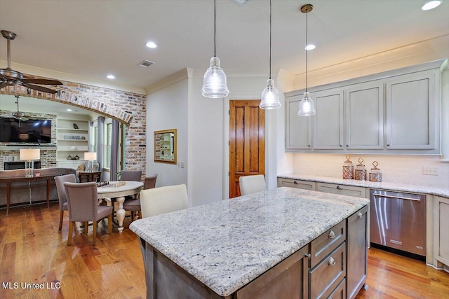 kitchen featuring light hardwood / wood-style floors, dishwasher, decorative light fixtures, and a kitchen island