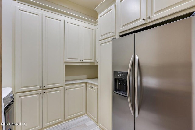 kitchen featuring light hardwood / wood-style floors, stainless steel fridge with ice dispenser, and white cabinets