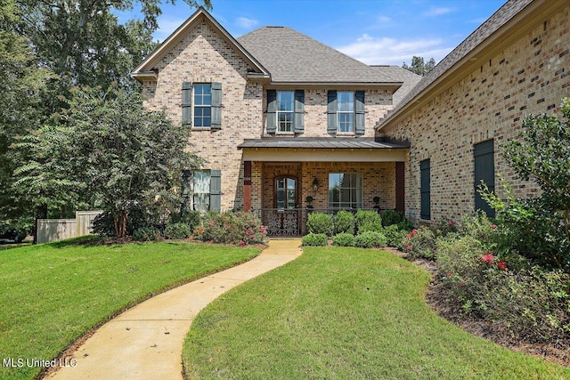 view of property with covered porch and a front yard